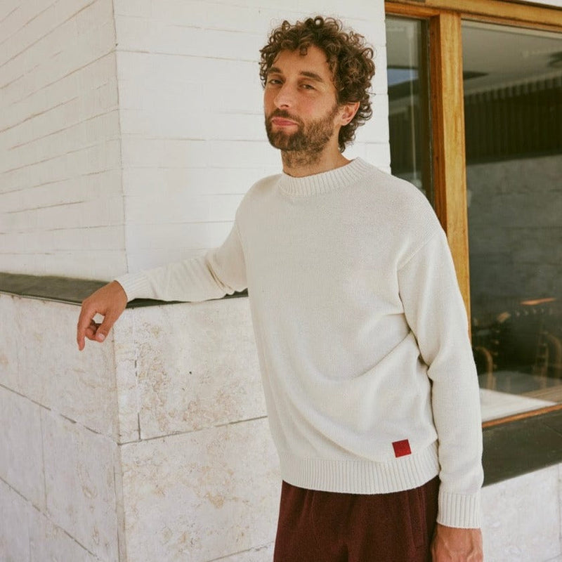 Model in a cream crewneck in a sunlit interior