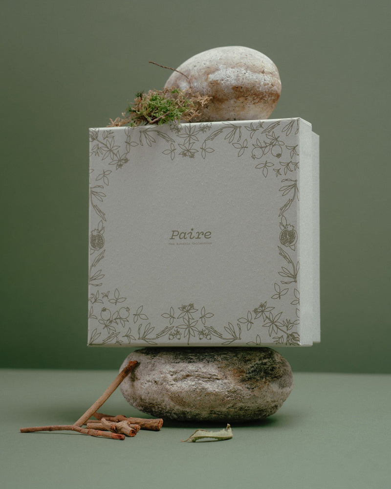 Sock gift box styled on a plinth against a deep green backdrop